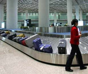 行李传送带飞机还没落地时就要拿行李是因为怕自己的东西被别人拿走或者被摔坏。团团包围行李传送带也是因为这个原因。