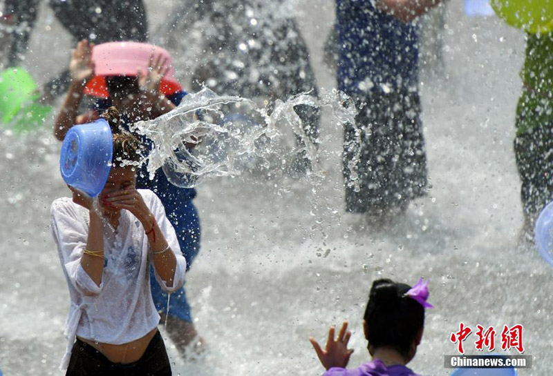 Einheimische und Touristen feiern gemeinsam das Wasserfest in Yunnan