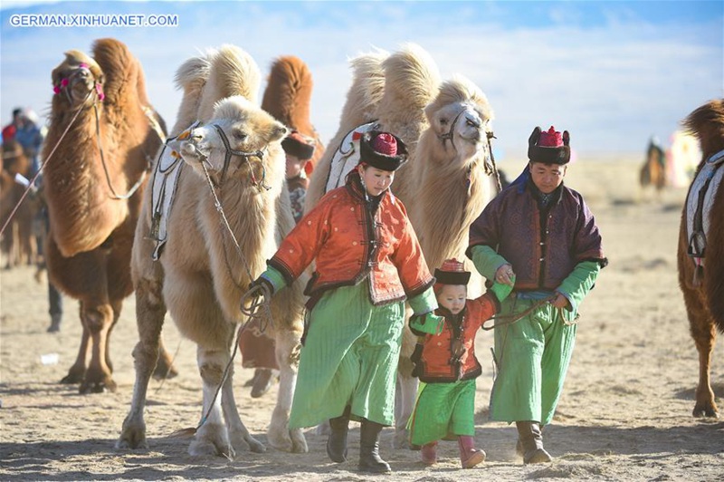 Menschen feiern auf Kamelen in Bayan Nur