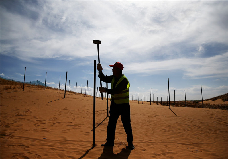 Sandkontrollarbeiter schützen Autobahnen in der Wüste